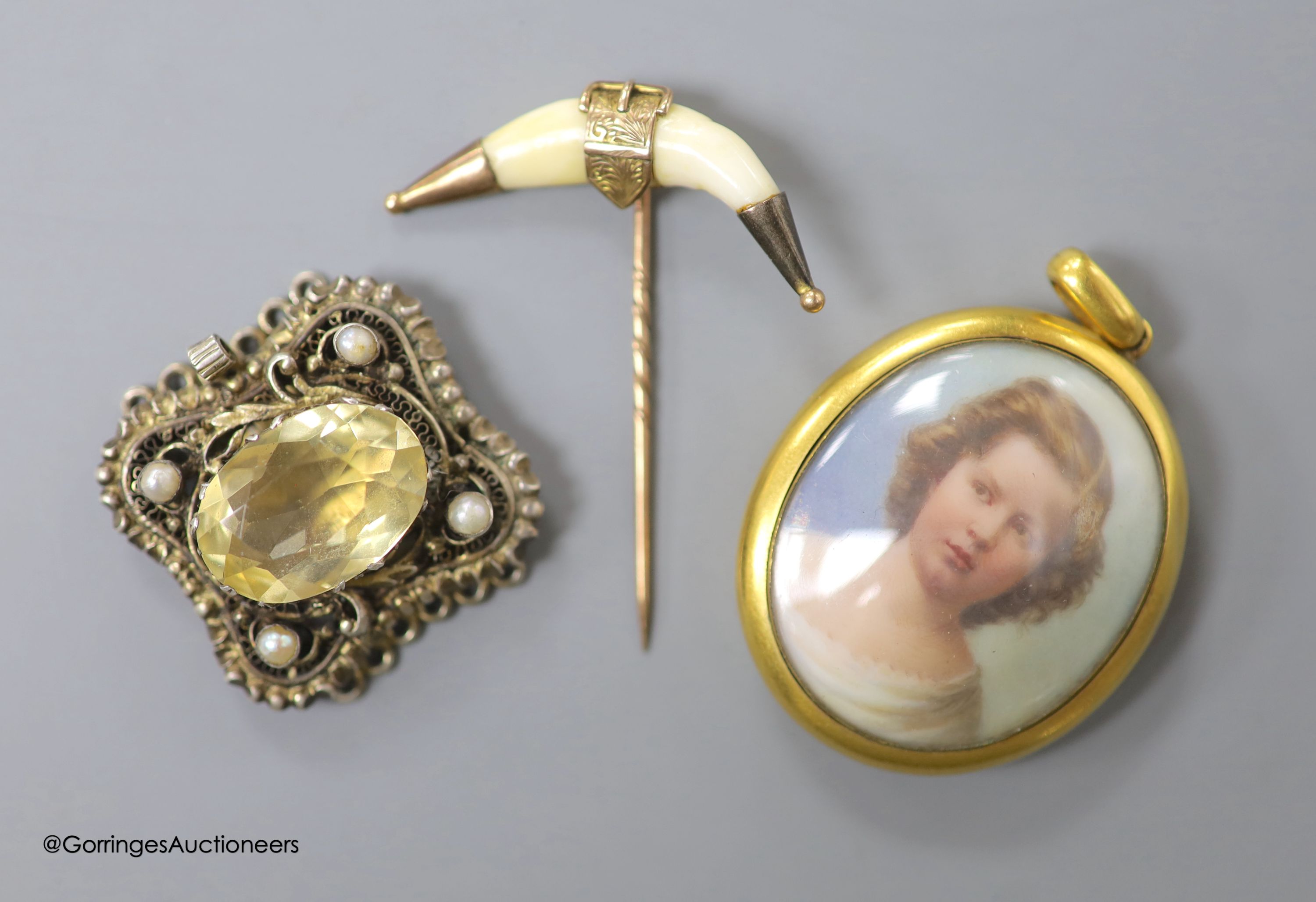 A Victorian yellow metal mounted glazed oval pendant, with miniature portrait of a young lady and plaited hair verso, 40mm, gross weight 18.1 grams, a yellow metal and tooth mounted stick pin and a gem set white metal cl